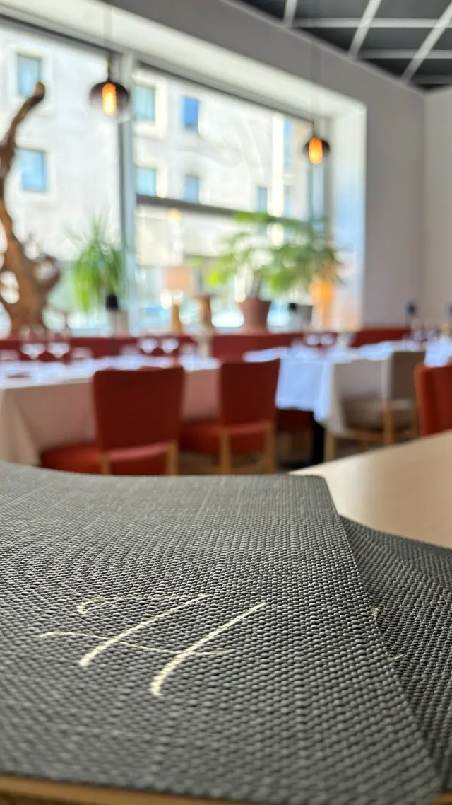 La carte au premier plan, la salle dressée pour le service