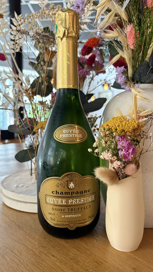 Une bouteille de champagne et un bouquet de fleurs séchées