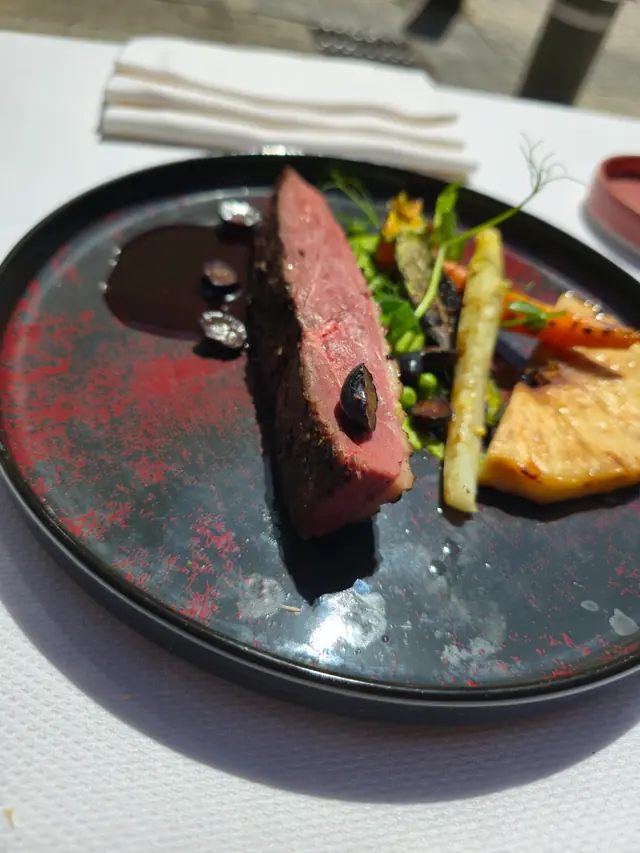 Magret rosé, jus corsé et légumes glacés, servi en terrasse