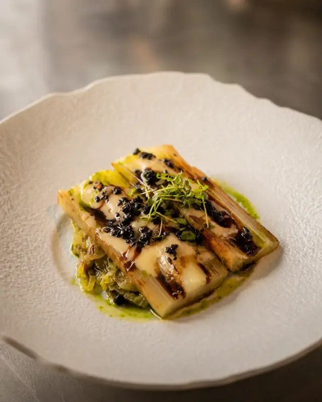 Le poireau brûlé dressé à l'assiette, vinaigrette tiède