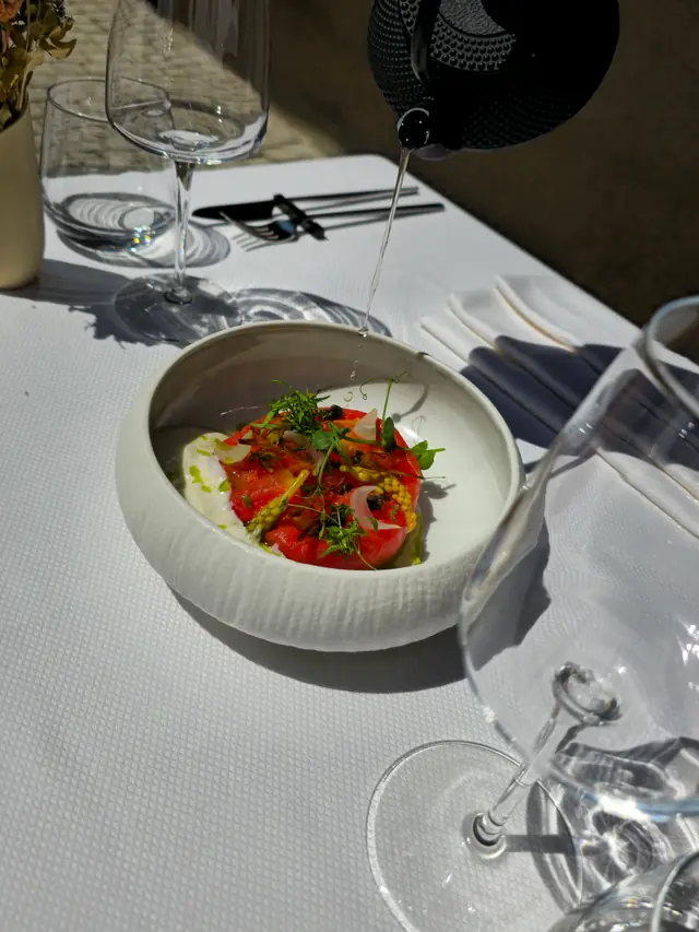 Tomates de plein champ et herbes fraîches, arrosées d'un filet d'huile au moment du service